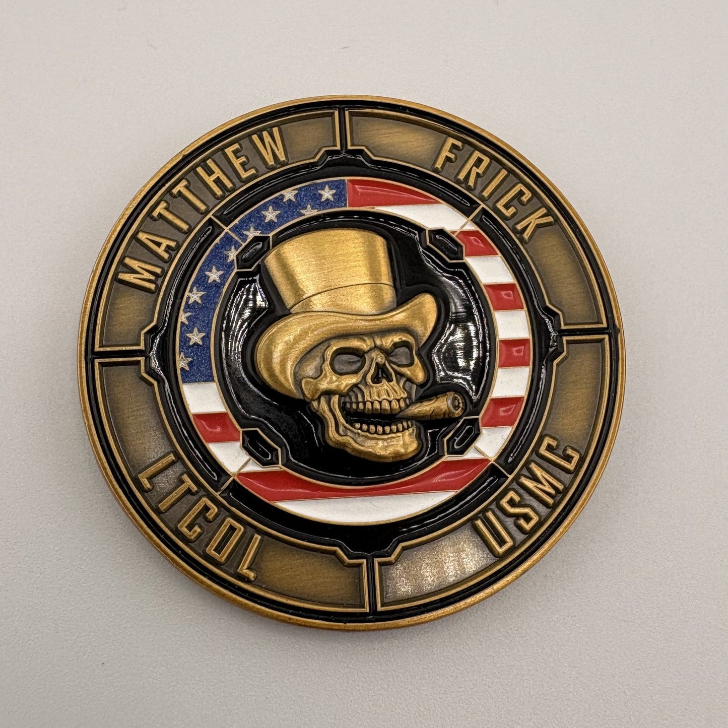 Full-color soft-enamel challenge coin with a hand-painted skull emblem and red, white and blue banding inside an antique-gold rope edge