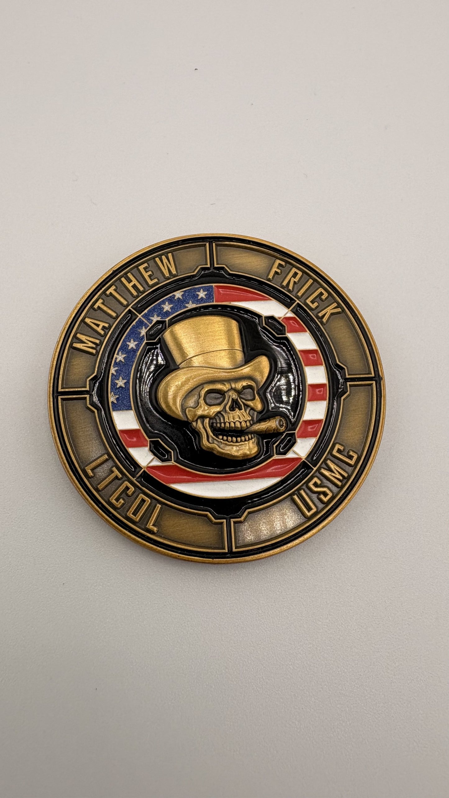 Full-color soft-enamel challenge coin with a hand-painted skull emblem and red, white and blue banding inside an antique-gold rope edge