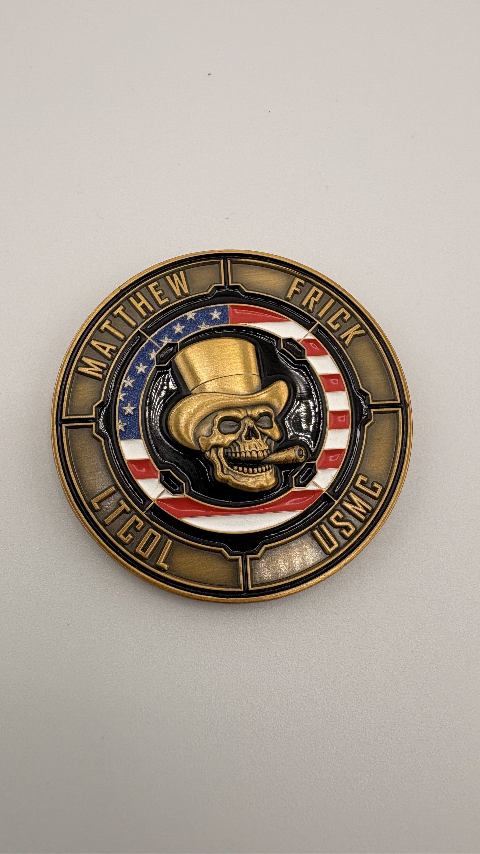 Full-color soft-enamel challenge coin with a hand-painted skull emblem and red, white and blue banding inside an antique-gold rope edge